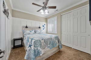 Bedroom with ceiling fan, ornamental molding, and a closet