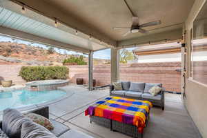 View of patio / terrace with outdoor lounge area, ceiling fan, a swimming pool with hot tub, and a mountain view