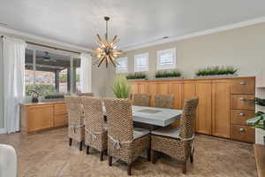 Dining space with ornamental molding and an inviting chandelier