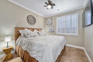 Bedroom featuring ceiling fan, ornamental molding, and light tile patterned floors