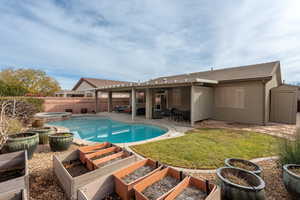 View of swimming pool featuring an in ground hot tub, a patio, an outdoor hangout area, and a lawn