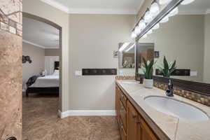 Bathroom featuring vanity and ornamental molding