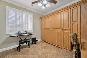 Interior space with ceiling fan and crown molding