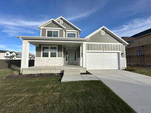 Craftsman-style house featuring a porch, a garage, and a front lawn