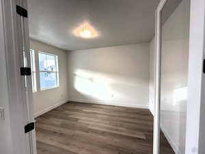 Spare room featuring a textured ceiling and dark hardwood / wood-style floors