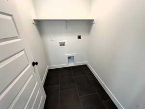 Laundry area with electric dryer hookup, dark tile patterned floors, and washer hookup