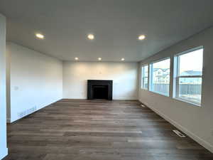 Unfurnished living room with dark wood-type flooring