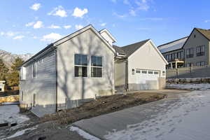 View of front of property featuring central AC unit, a garage, and a mountain view