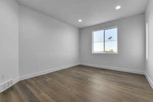 Spare room with dark wood-type flooring