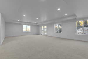 Empty room featuring light colored carpet and a raised ceiling