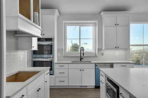 Kitchen featuring appliances with stainless steel finishes, sink, white cabinets, and plenty of natural light