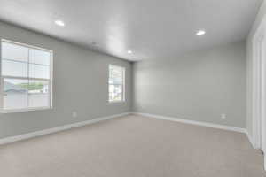 Carpeted spare room with a textured ceiling