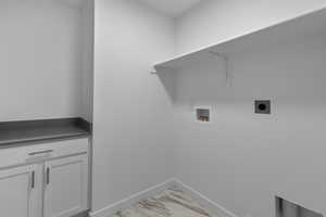 Washroom featuring hookup for an electric dryer, cabinets, and hookup for a washing machine