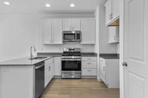 Kitchen featuring white cabinets, hardwood / wood-style floors, stainless steel appliances, and sink