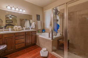 Bathroom featuring ceiling fan, independent shower and bath, and vanity