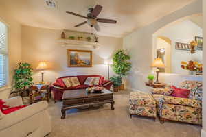 Living room featuring carpet flooring and ceiling fan