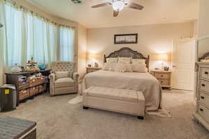 Carpeted bedroom featuring ceiling fan