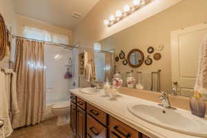 Full bathroom featuring tile patterned flooring, vanity, shower / tub combo, and toilet