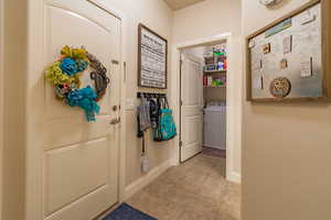 Doorway to outside featuring light tile patterned floors and washer / clothes dryer