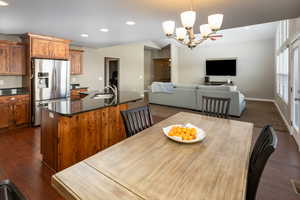 Dining space with dark hardwood / wood-style floors, a notable chandelier, and sink