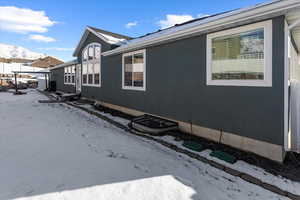 View of snow covered exterior featuring a mountain view