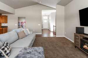 Living room with dark carpet and vaulted ceiling