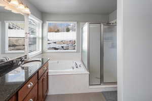 Bathroom featuring separate shower and tub, tile patterned floors, and vanity