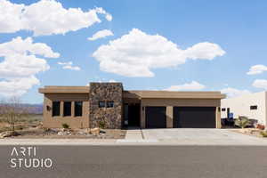 Pueblo revival-style home featuring a garage