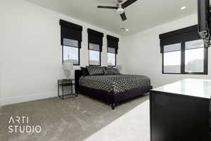 Carpeted bedroom featuring multiple windows and ceiling fan