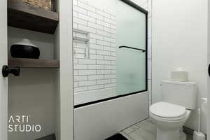 Bathroom featuring toilet and enclosed tub / shower combo