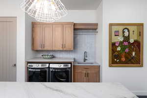 Interior space featuring washing machine and dryer, sink, and cabinets