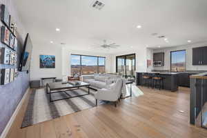 Living room with ceiling fan and light hardwood / wood-style flooring