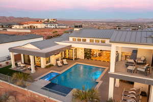 Pool at dusk with a patio area and a mountain view