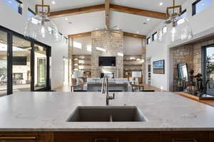 Kitchen with beam ceiling, high vaulted ceiling, and sink