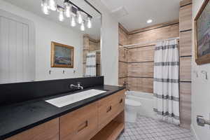 Full bathroom with tile patterned flooring, vanity, toilet, and shower / bathtub combination with curtain