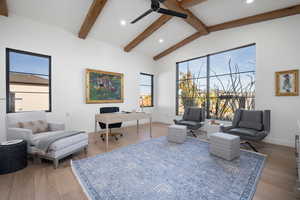 Living area with vaulted ceiling with beams, ceiling fan, and wood-type flooring