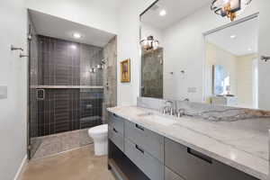 Bathroom with a shower with door, vanity, concrete floors, and toilet