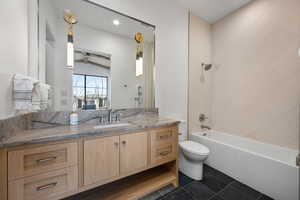 Full bathroom with tile patterned flooring, vanity, toilet, and tiled shower / bath