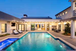 View of swimming pool with a patio, an in ground hot tub, and exterior fireplace