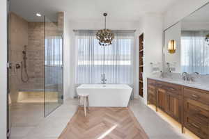 Bathroom featuring vanity, plus walk in shower, and an inviting chandelier