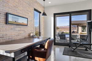 Interior space featuring concrete flooring, a mountain view, and brick wall