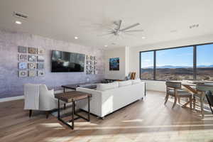 Living room with ceiling fan and light hardwood / wood-style flooring