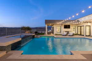 View of swimming pool with pool water feature, an in ground hot tub, an outdoor fireplace, and a patio