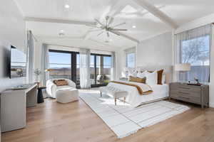 Bedroom with french doors, vaulted ceiling with beams, ceiling fan, multiple windows, and light hardwood / wood-style floors