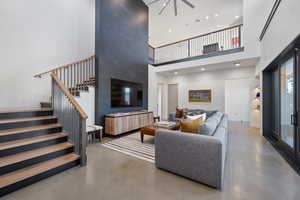 Living room with concrete flooring and a high ceiling