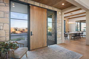 Doorway featuring wooden ceiling, beamed ceiling, and light hardwood / wood-style floors