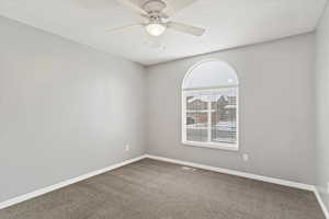 Carpeted empty room with ceiling fan