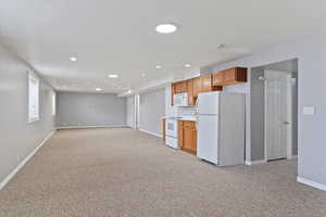 Kitchen featuring light carpet and white appliances