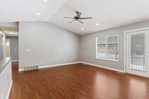 Unfurnished room featuring dark hardwood / wood-style floors, ceiling fan, and lofted ceiling