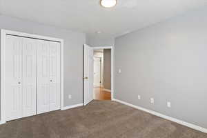 Unfurnished bedroom featuring a closet and carpet